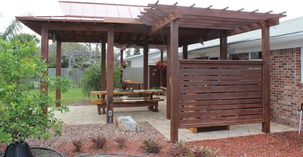 Idee per un patio o portico costiero di medie dimensioni e dietro casa con pavimentazioni in cemento e una pergola