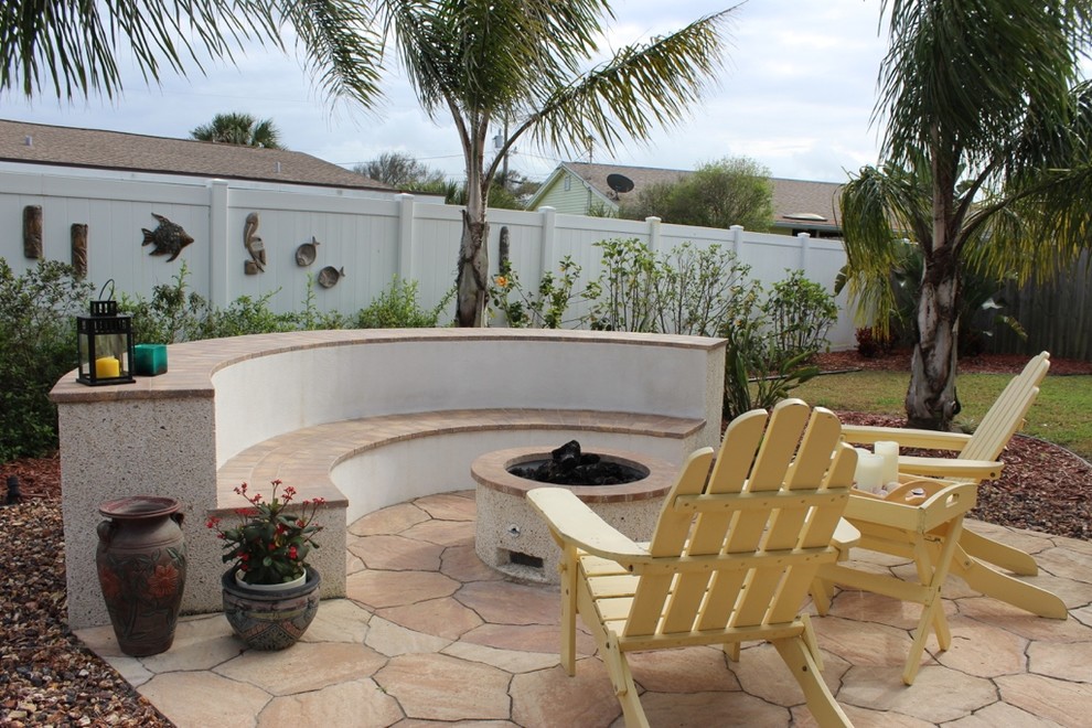 Diseño de patio costero de tamaño medio en patio trasero con brasero, adoquines de hormigón y pérgola
