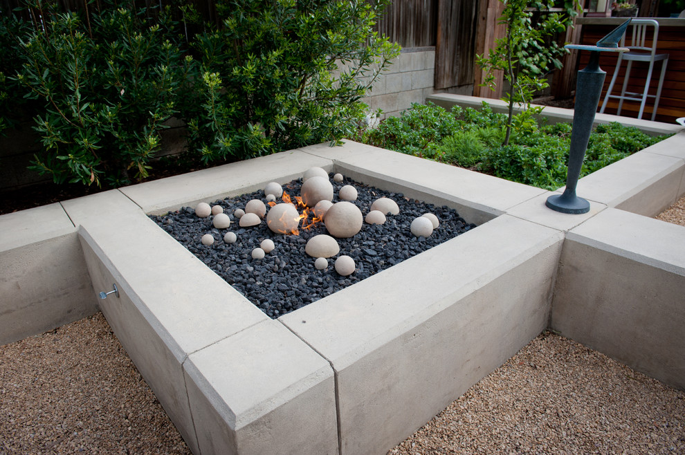 Large modern back patio in Los Angeles with a fire feature and gravel.