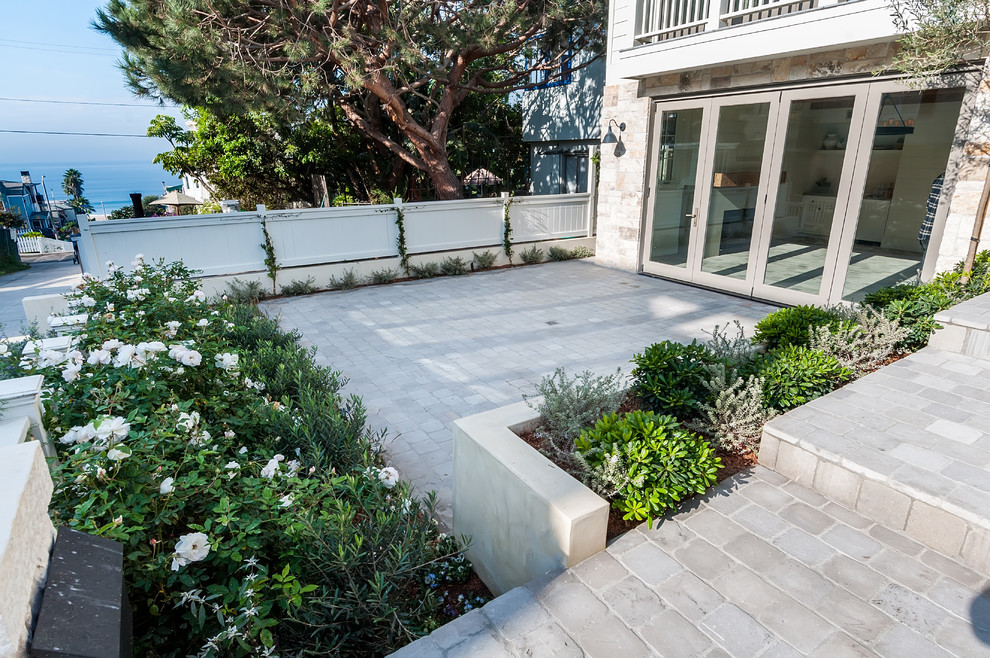This is an example of a medium sized rural front patio in San Diego with natural stone paving.
