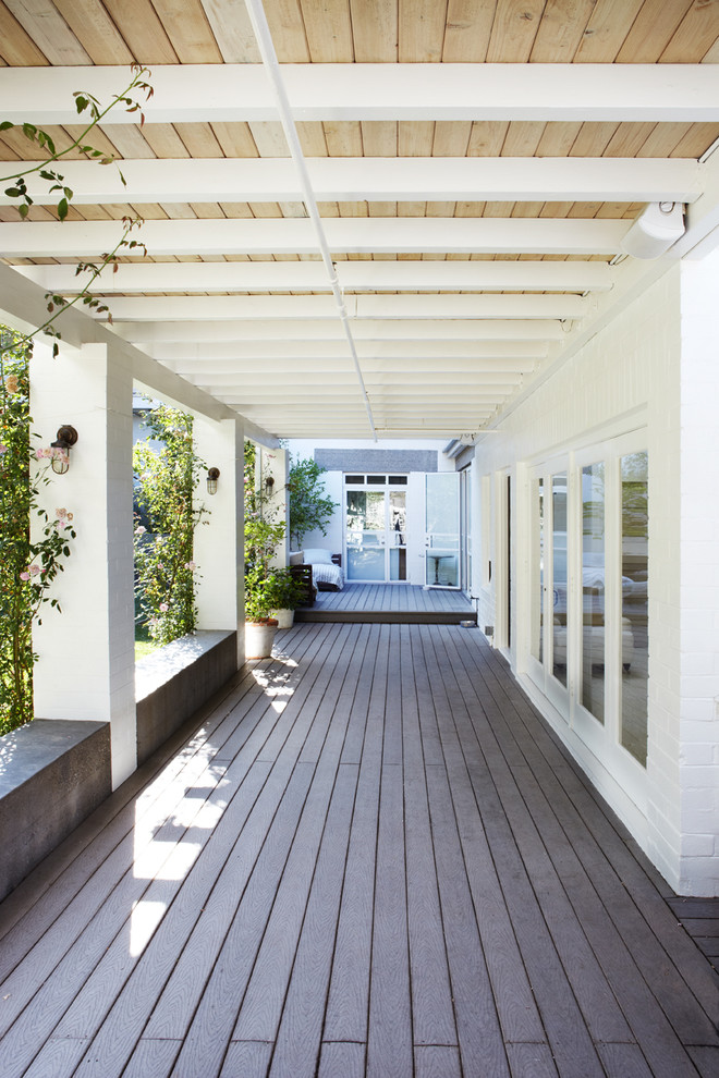 Mid-sized urban side yard patio photo in Orange County with decking and a roof extension