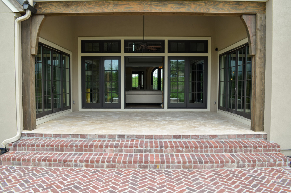 Esempio di un grande patio o portico design dietro casa con pavimentazioni in pietra naturale e un tetto a sbalzo