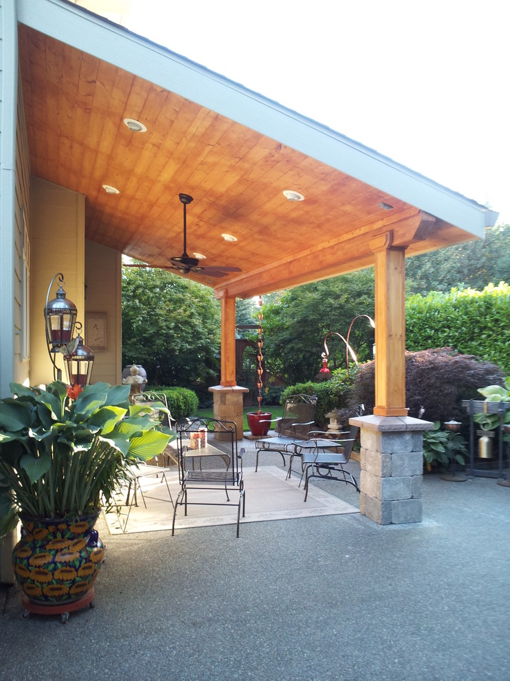 Immagine di un patio o portico minimal dietro casa e di medie dimensioni con un tetto a sbalzo e lastre di cemento