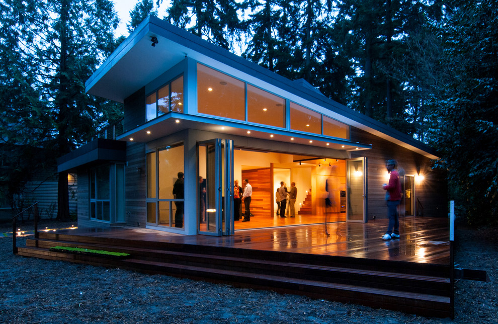 Immagine di un grande patio o portico design dietro casa con pedane e un tetto a sbalzo