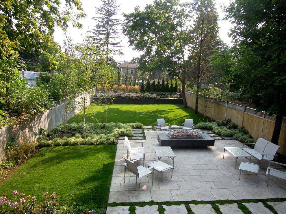 На фото: двор на заднем дворе в классическом стиле с местом для костра и покрытием из каменной брусчатки без защиты от солнца