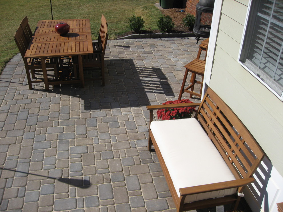 Example of a mid-sized trendy backyard concrete paver patio design in Raleigh with no cover