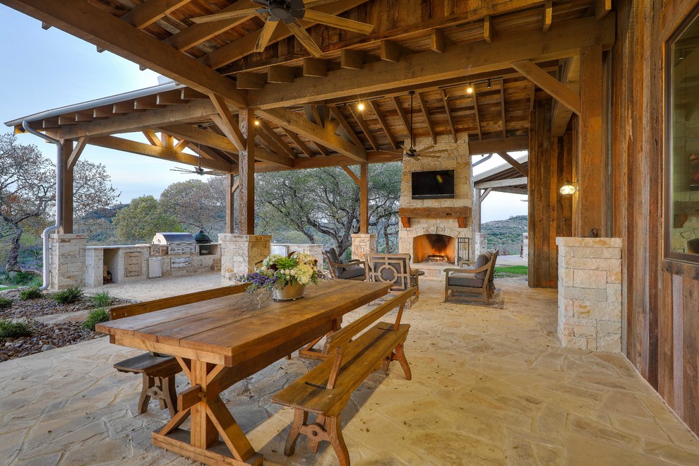 Photo of a farmhouse back patio in Austin with tiled flooring, a roof extension and a fireplace.
