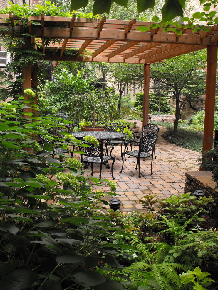 This is an example of a large victorian back patio in New York with a pergola and brick paving.