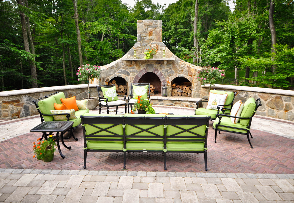Inspiration pour une terrasse traditionnelle avec des pavés en brique et un foyer extérieur.