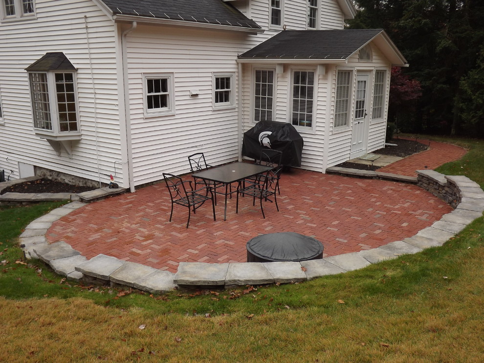 Example of a mid-sized classic backyard brick patio design in Orange County with no cover