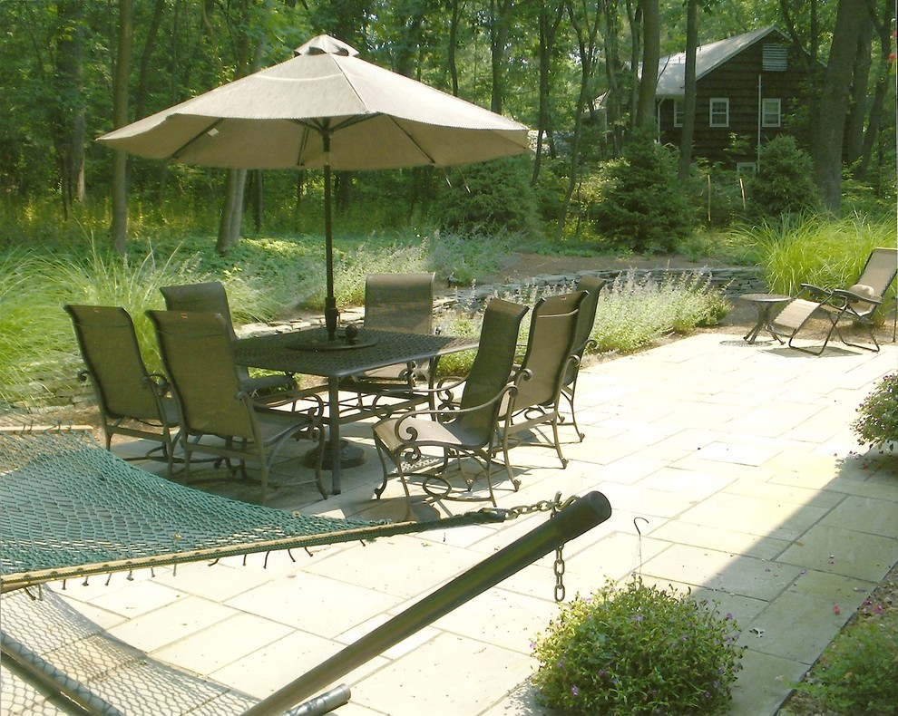 Imagen de patio tradicional de tamaño medio sin cubierta en patio trasero con adoquines de piedra natural