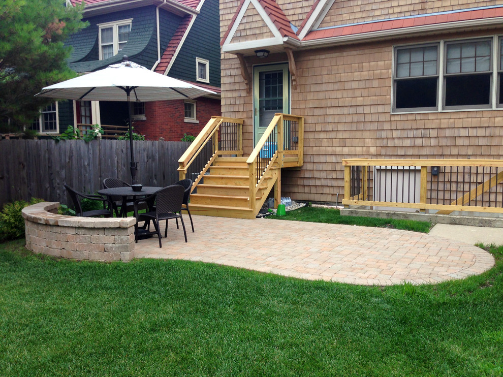 Medium sized classic back patio in Chicago with brick paving.
