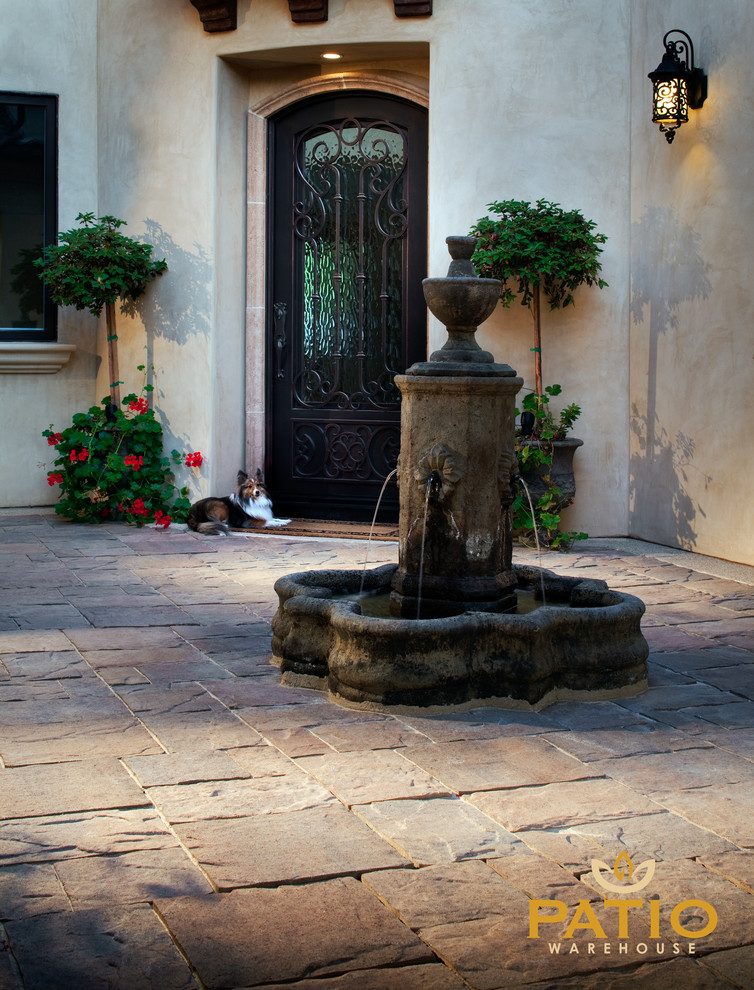 Esempio di un patio o portico stile rurale dietro casa con pavimentazioni in cemento