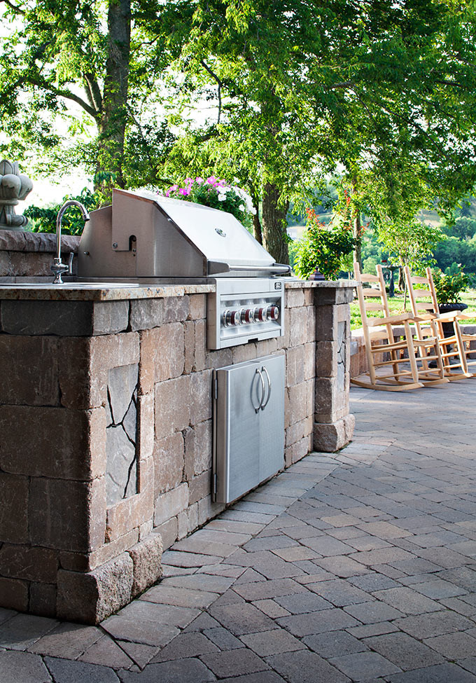 Inspiration for a mid-sized timeless backyard stone patio kitchen remodel in Other with no cover