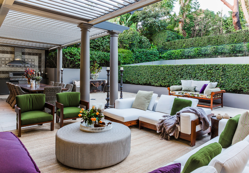 Diseño de patio tradicional de tamaño medio en patio trasero con cocina exterior, pérgola y adoquines de hormigón