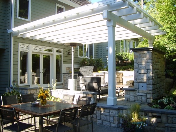 Modelo de patio clásico grande en patio trasero con cocina exterior, adoquines de piedra natural y pérgola