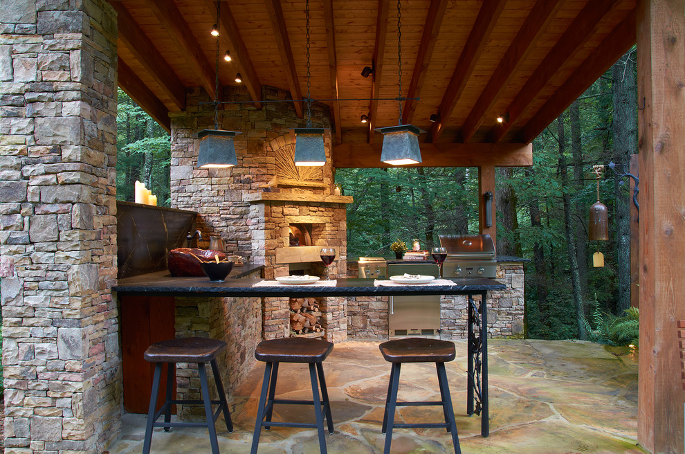 Idée de décoration pour une terrasse arrière chalet de taille moyenne avec des pavés en pierre naturelle et un gazebo ou pavillon.