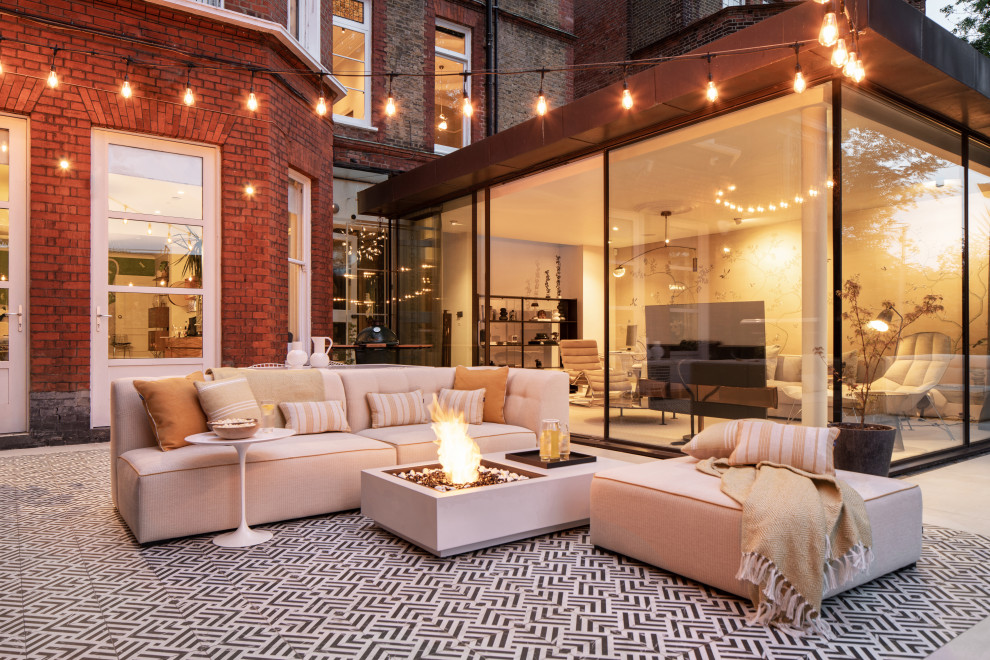 Contemporary patio in London with a fire feature, tiled flooring and no cover.