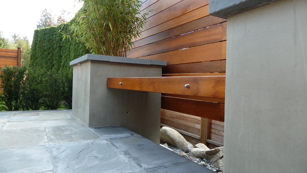 Idées déco pour une terrasse arrière craftsman de taille moyenne avec un foyer extérieur, des pavés en pierre naturelle et une extension de toiture.