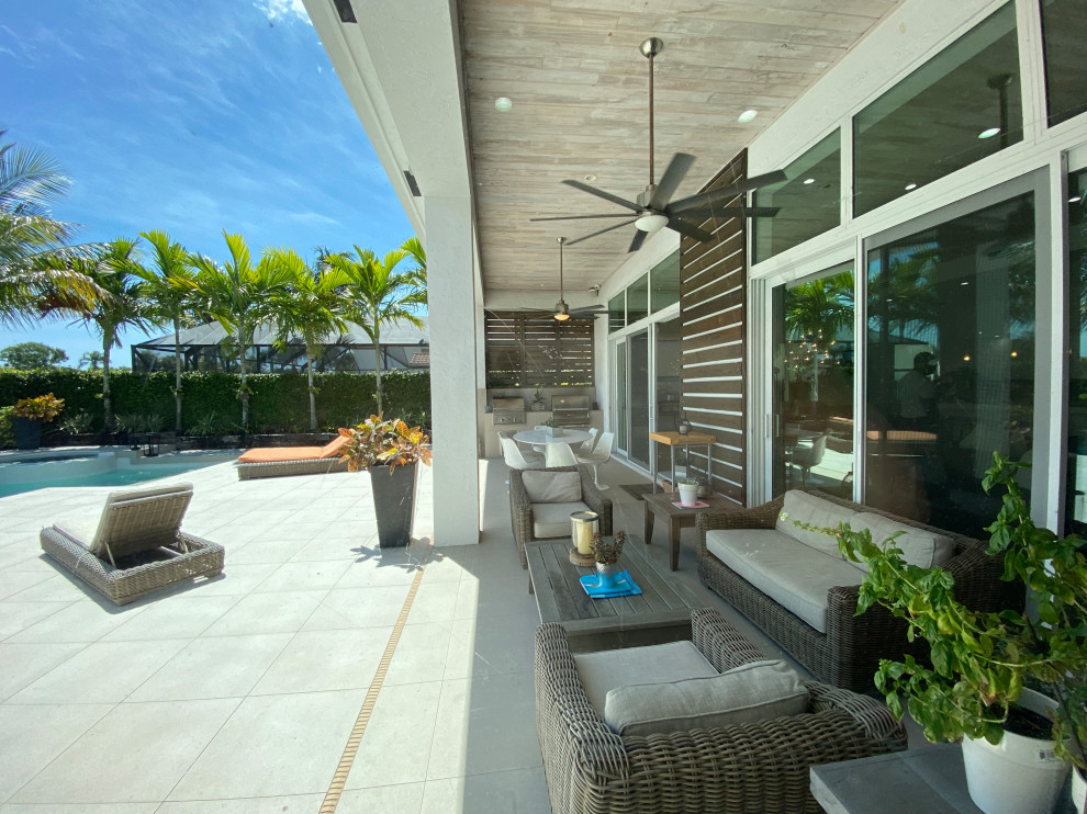 Foto di un grande patio o portico moderno dietro casa con un parasole
