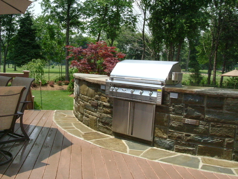 Modelo de patio clásico de tamaño medio en patio trasero con cocina exterior y entablado