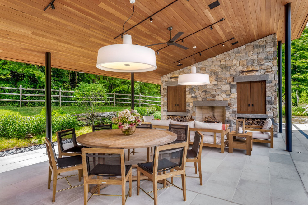 Inspiration for a contemporary backyard patio remodel in Boston with a fireplace and a roof extension