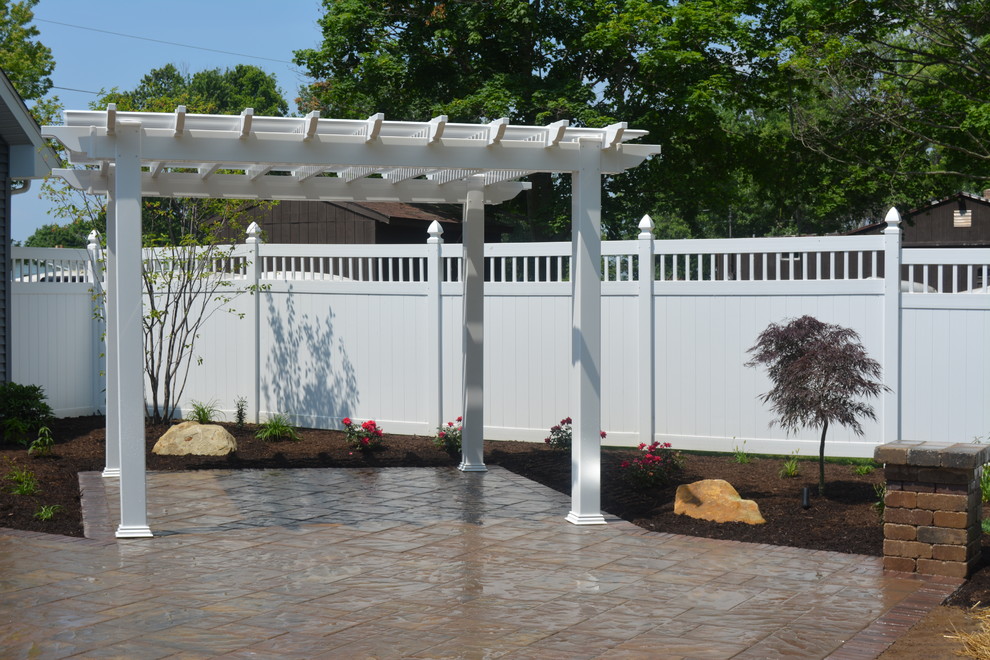 Immagine di un patio o portico contemporaneo di medie dimensioni e dietro casa con un focolare, pavimentazioni in mattoni e una pergola