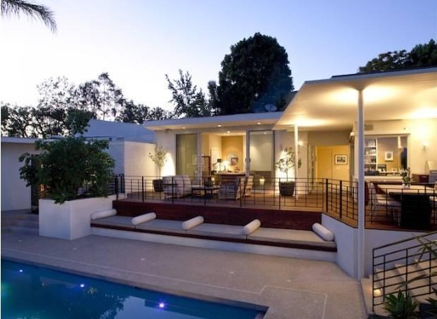 Réalisation d'une grande terrasse arrière design avec une cuisine d'été, une dalle de béton et une extension de toiture.