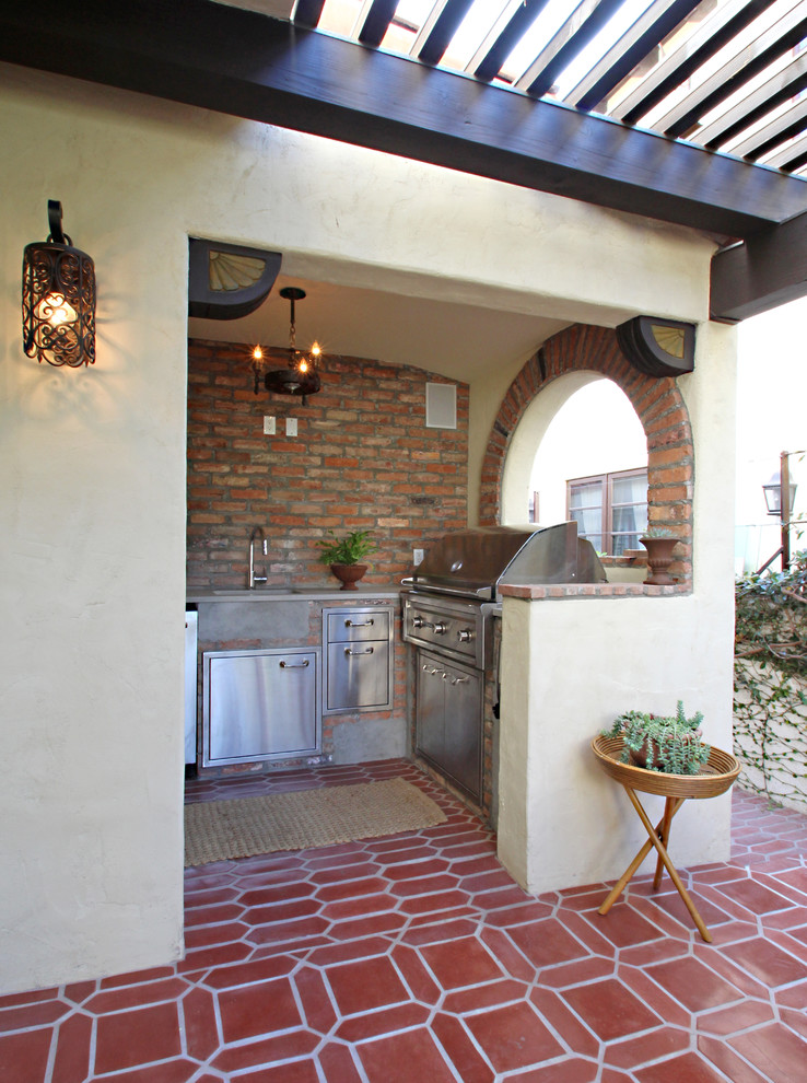 Foto de patio mediterráneo en patio lateral con cocina exterior, suelo de baldosas y pérgola