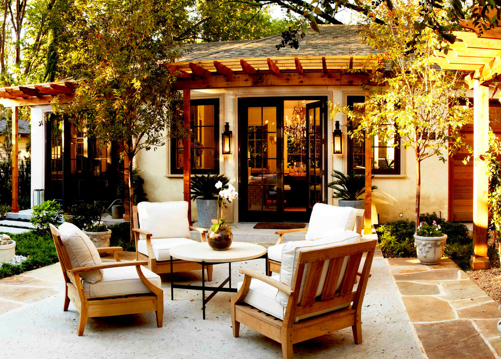 Immagine di un patio o portico chic di medie dimensioni e dietro casa con pavimentazioni in pietra naturale e una pergola