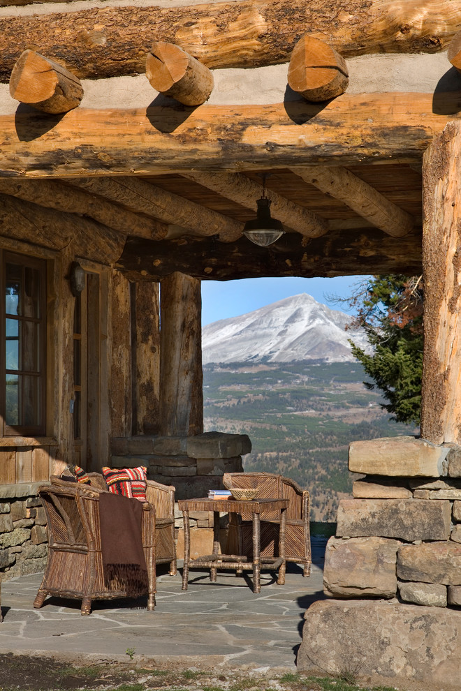 Cette photo montre une terrasse montagne avec des pavés en pierre naturelle et une extension de toiture.
