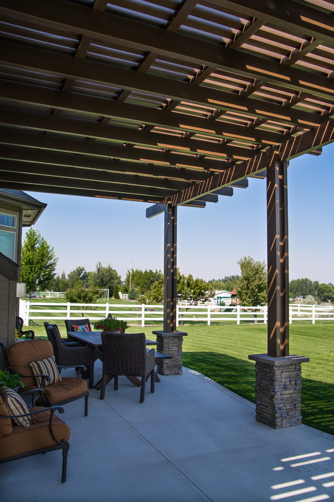Design ideas for a large classic back patio in Boise with a pergola.