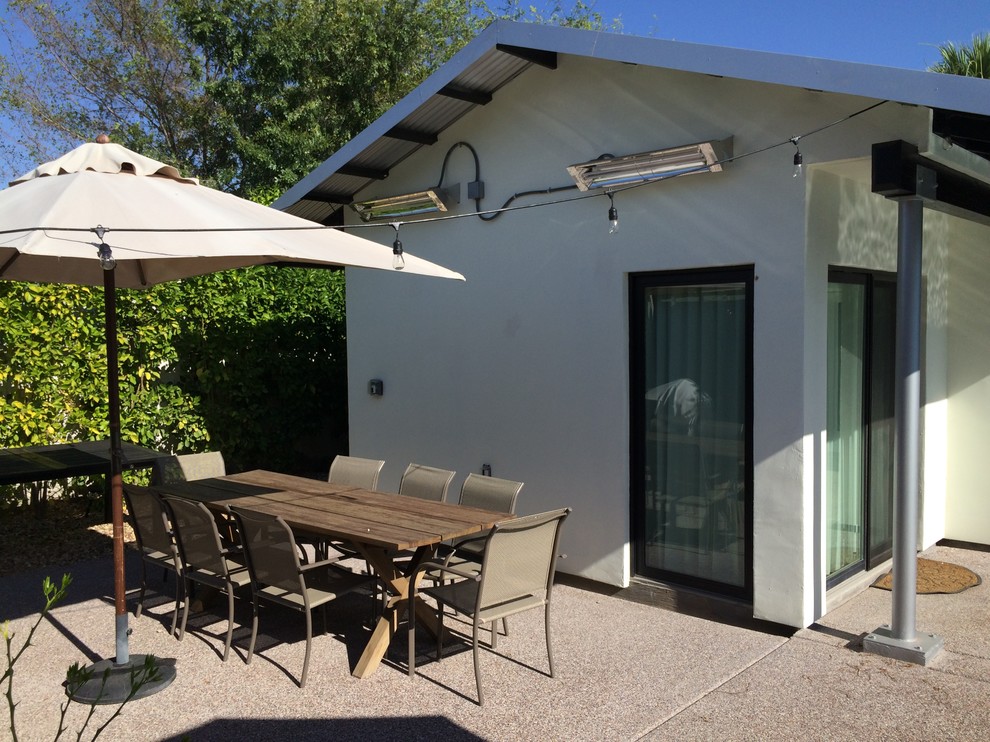 Design ideas for a retro back patio in Phoenix with concrete slabs and an awning.