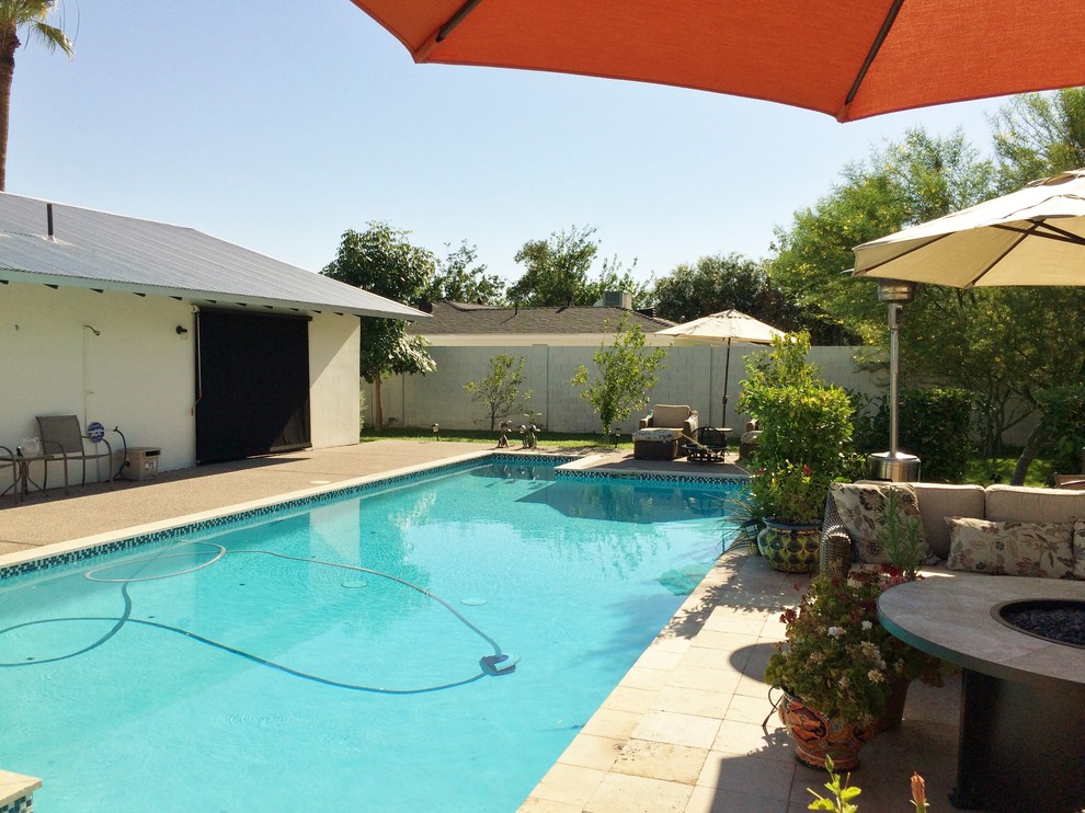 Imagen de piscina retro en patio trasero con losas de hormigón