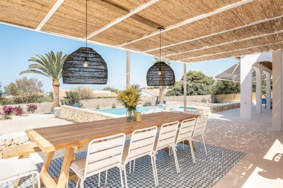 Diseño de patio mediterráneo con losas de hormigón y cenador