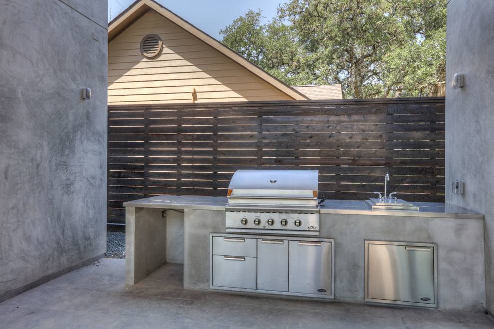 Foto de patio moderno de tamaño medio sin cubierta en patio trasero con cocina exterior y adoquines de hormigón