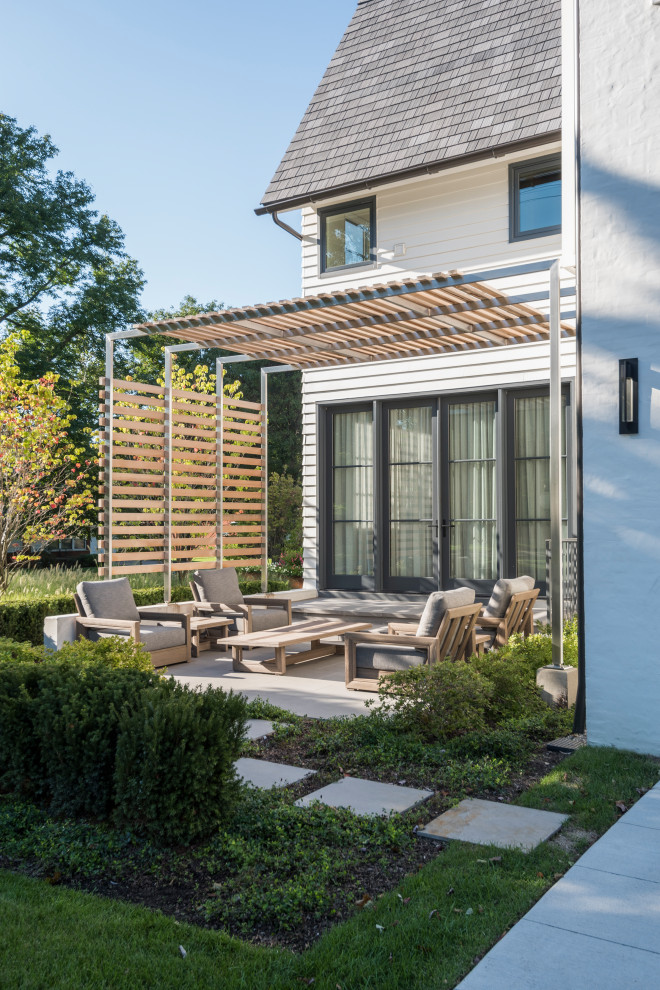 Immagine di un patio o portico minimal nel cortile laterale con piastrelle e una pergola