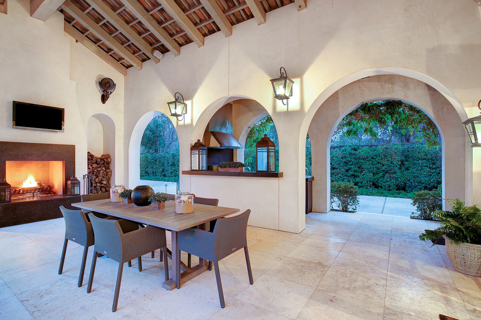 Idee per un patio o portico mediterraneo dietro casa con pavimentazioni in pietra naturale, un gazebo o capanno e un caminetto