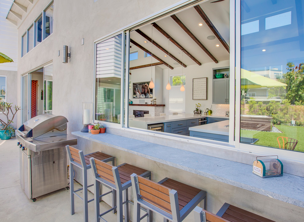 Exemple d'une grande terrasse arrière tendance avec une cuisine d'été, des pavés en béton et une extension de toiture.