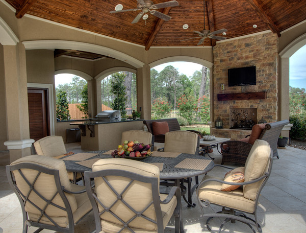 Exemple d'une très grande terrasse arrière chic avec une cuisine d'été, des pavés en pierre naturelle et une extension de toiture.