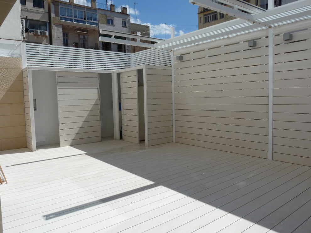 This is an example of a large modern back patio in Valencia with an outdoor shower and an awning.