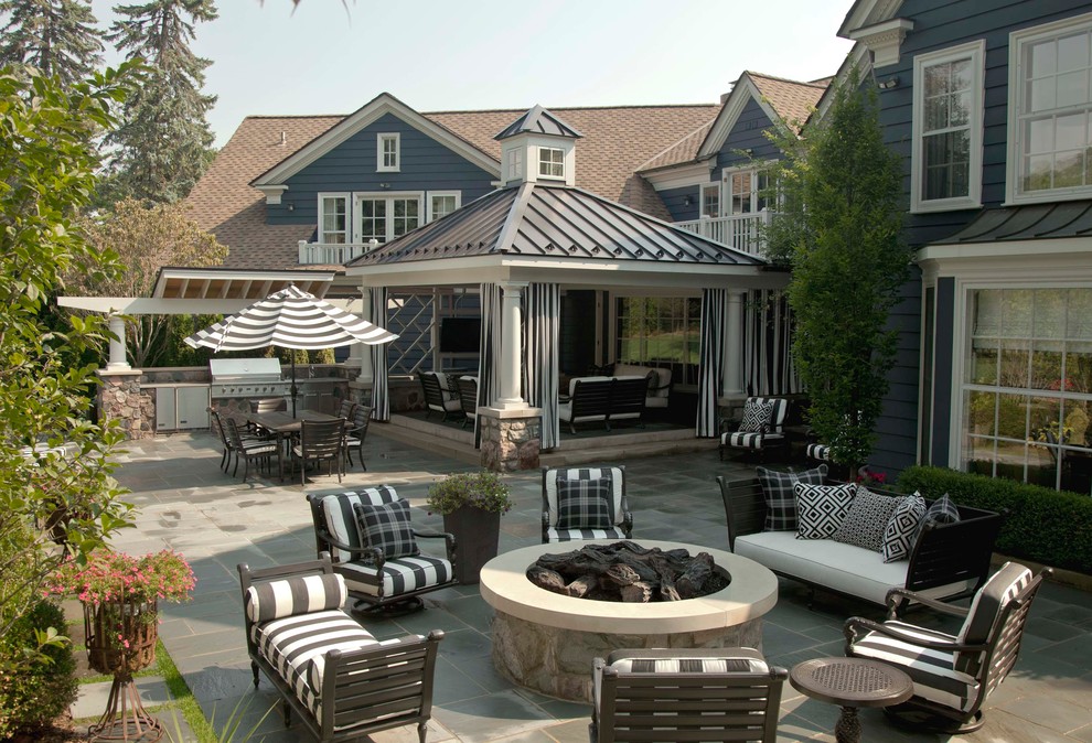 Idées déco pour une grande terrasse arrière classique avec une cuisine d'été et une extension de toiture.