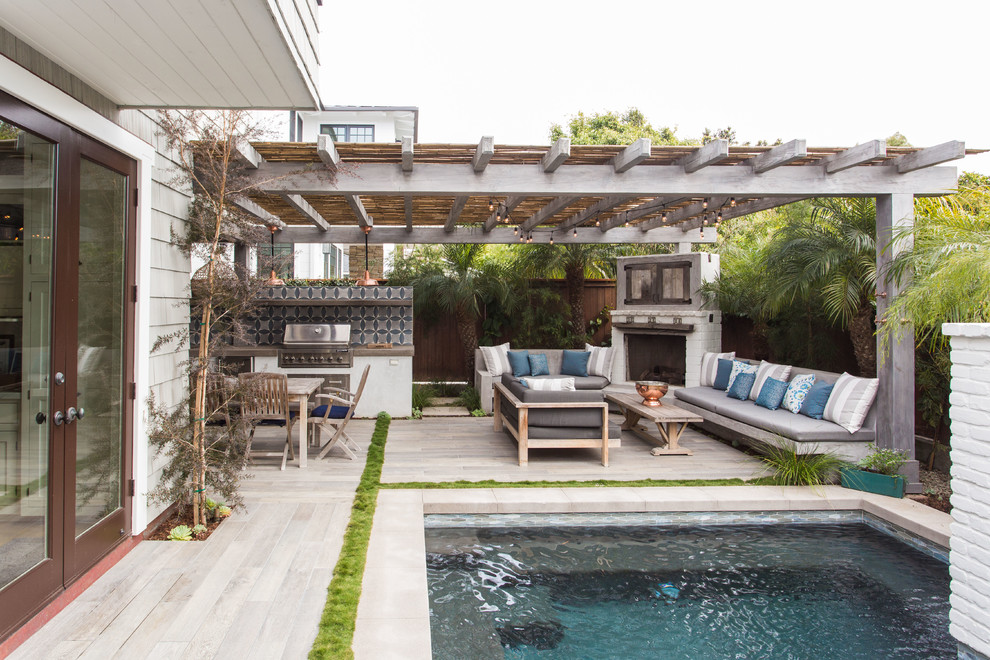 Inspiration for a medium sized classic back patio in Los Angeles with an outdoor kitchen, concrete slabs and a pergola.