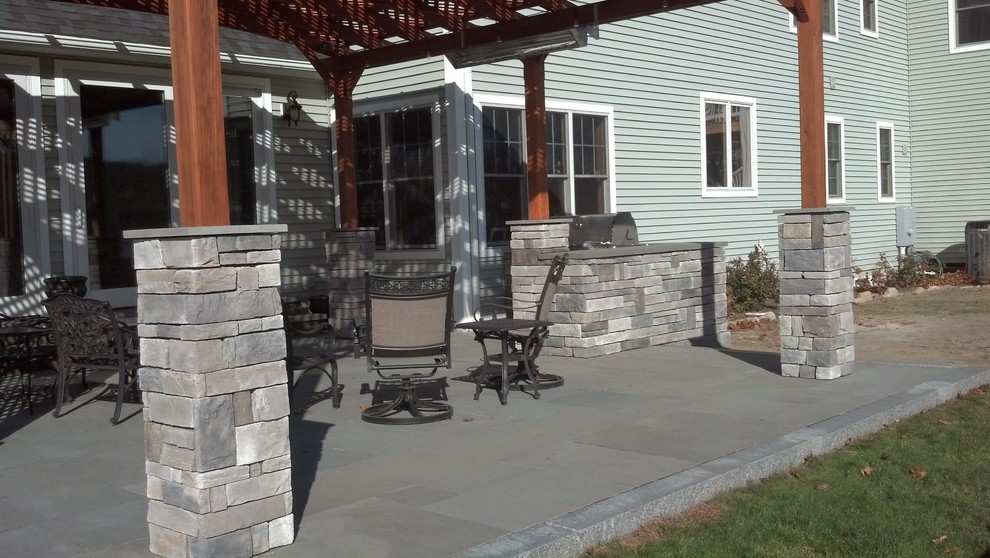 Ejemplo de patio tradicional renovado de tamaño medio en patio trasero con cocina exterior, adoquines de piedra natural y pérgola