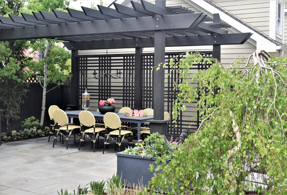 Cette photo montre une petite terrasse arrière tendance avec un foyer extérieur, des pavés en pierre naturelle et une pergola.