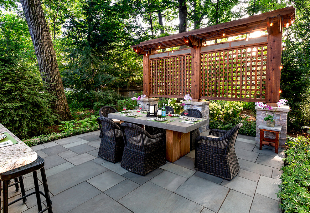 Große Klassische Pergola hinter dem Haus mit Outdoor-Küche und Natursteinplatten in Chicago