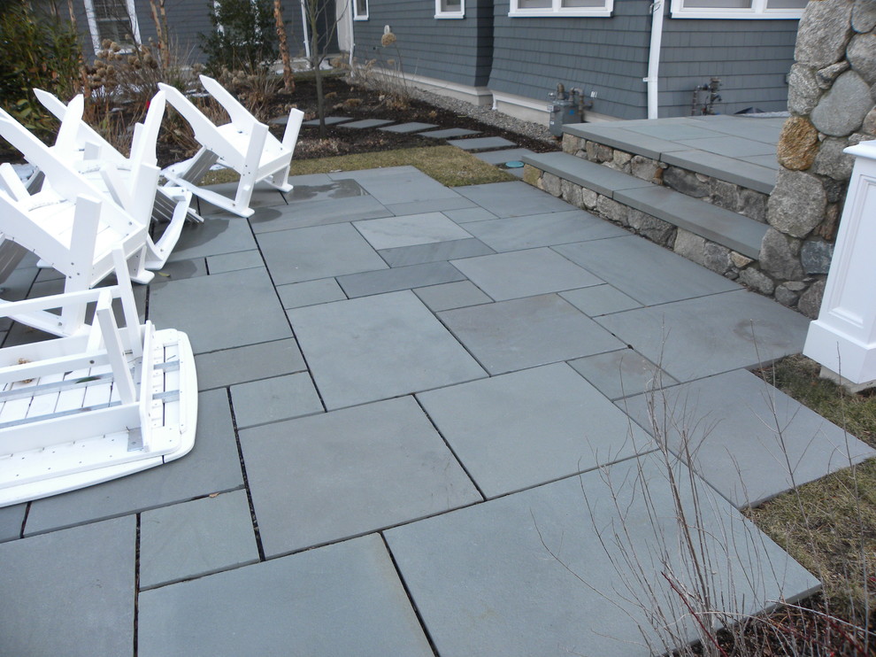 Photo of a medium sized classic back patio in Boston with a fire feature, natural stone paving and no cover.