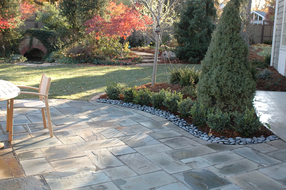 Immagine di un grande patio o portico classico dietro casa con pavimentazioni in pietra naturale