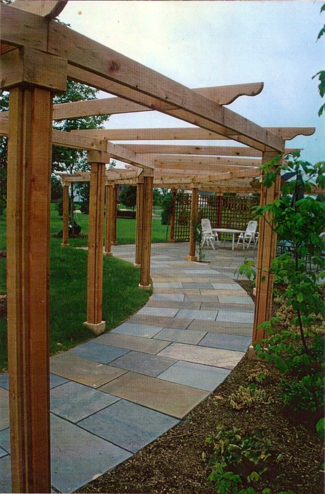 Idee per un patio o portico chic di medie dimensioni e dietro casa con pavimentazioni in pietra naturale e una pergola