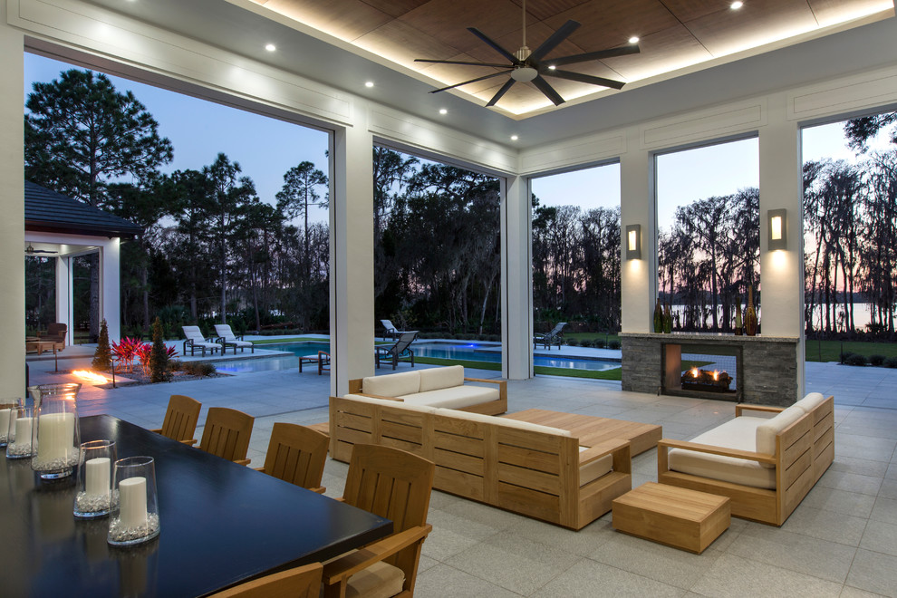 Photo of a large contemporary back patio in Orlando with a fireplace and a roof extension.
